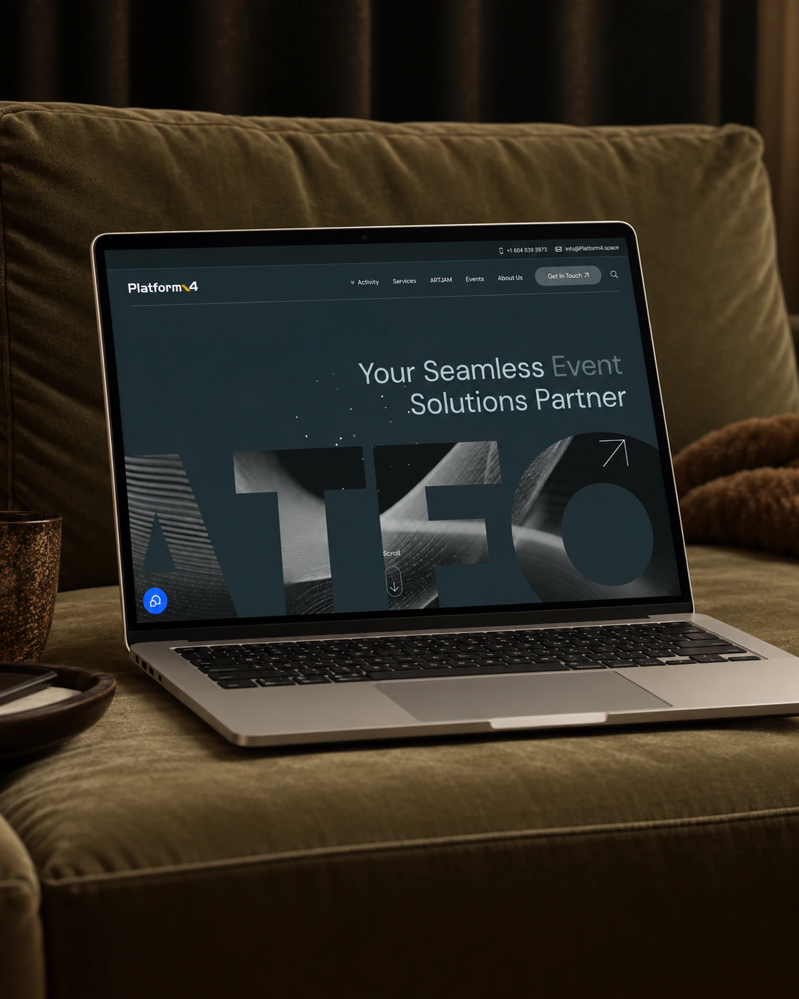 Platform4 event space homepage on a laptop, on a green velvet sofa