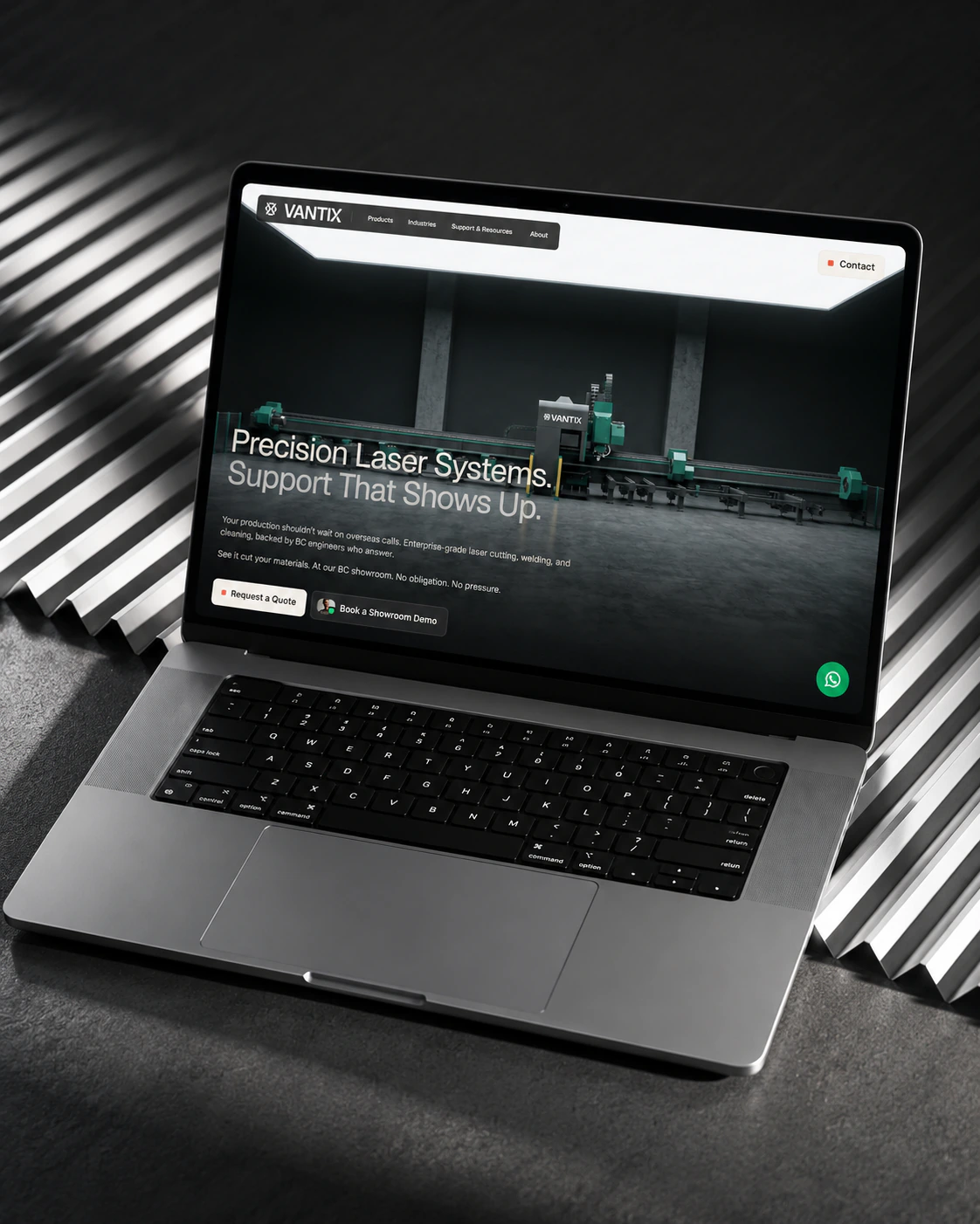 Vantix Industrial Lasers homepage on a laptop, on corrugated steel: Precision Laser Systems hero
