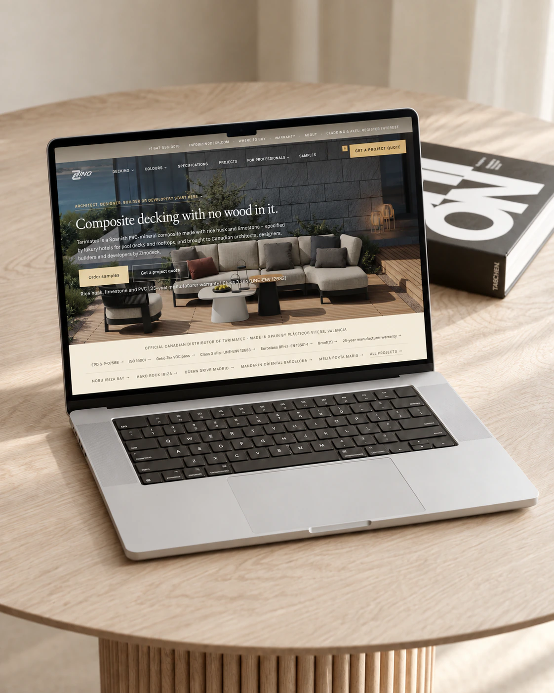 Zinodeck composite decking homepage on a laptop, set on a round oak table